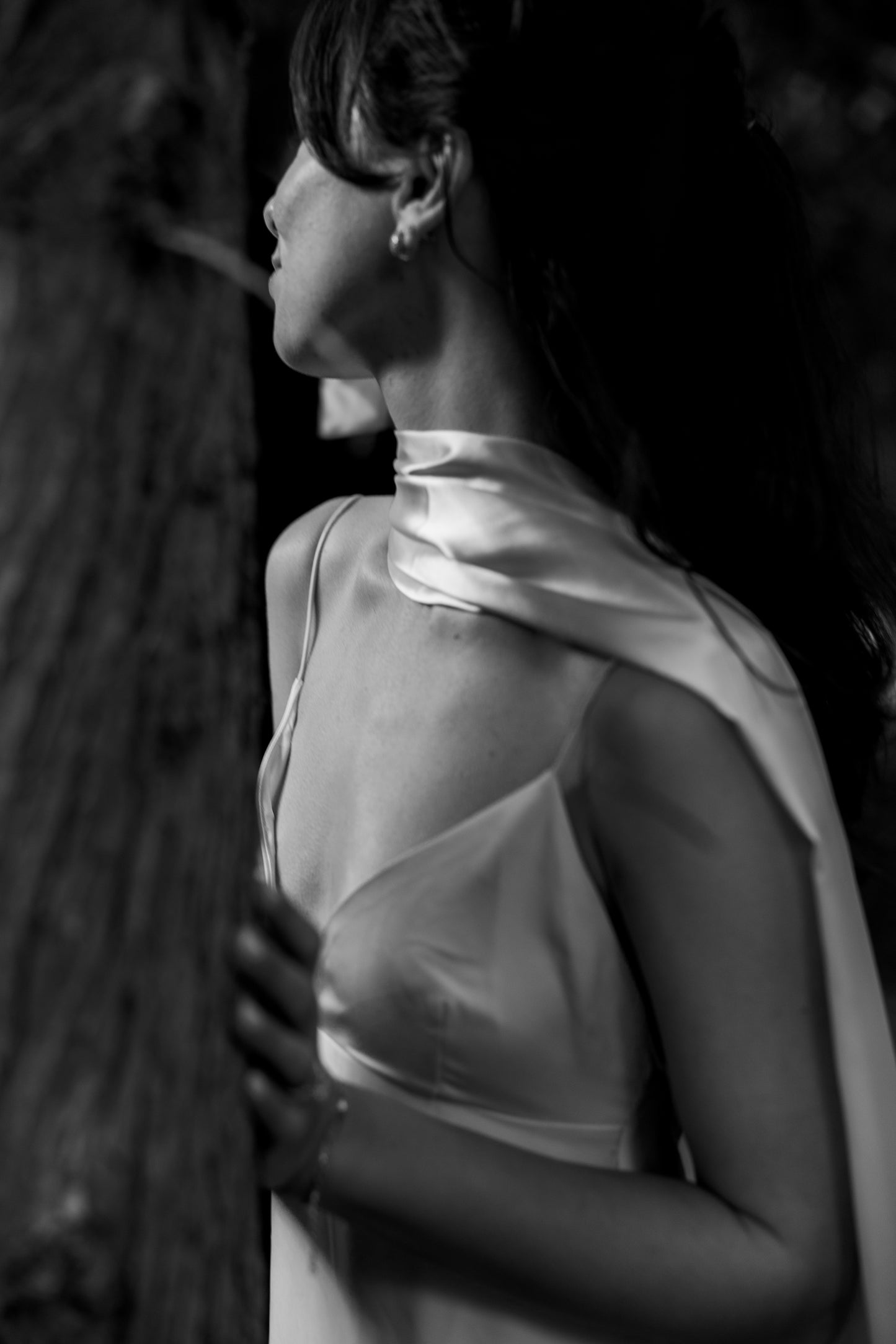Black and white portrait of a woman with a draped satin scarf over her shoulder.